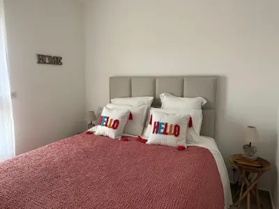 a bed with white pillows with the word hello on it at T4 Cala Rossa - 3 Ch - Piscine et Plage à pied in Lecci