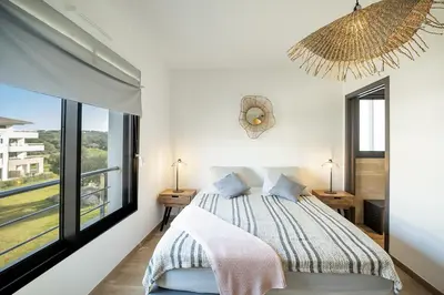 a bedroom with a bed and a large window at Domaine d'Arca - Gauguin 12 - 6 pers in Porto-Vecchio
