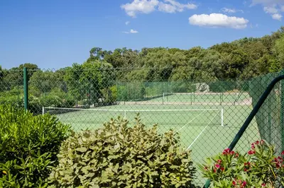 a tennis court with a net on a court at Domaine d'Arca - Flaubert 06 - 6 pers in Porto-Vecchio