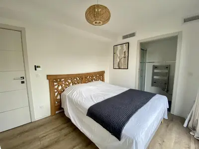 a bedroom with a large bed with a wooden headboard at Domaine d'Arca - Flaubert 06 - 6 pers in Porto-Vecchio