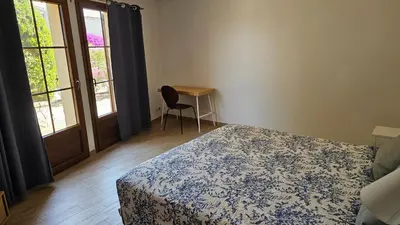 a bedroom with a bed and a desk with a chair at RESIDENCE GIULIA in Propriano