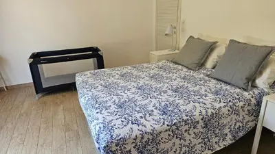 a bedroom with a bed with a blue and white blanket at RESIDENCE GIULIA in Propriano