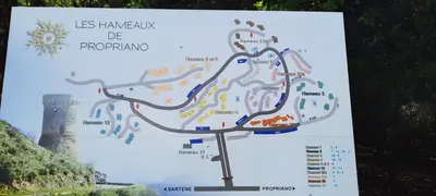 a sign with a map with a lighthouse in the background at RESIDENCE GIULIA in Propriano