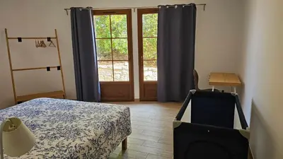 a bedroom with a bed and a large window at RESIDENCE GIULIA in Propriano