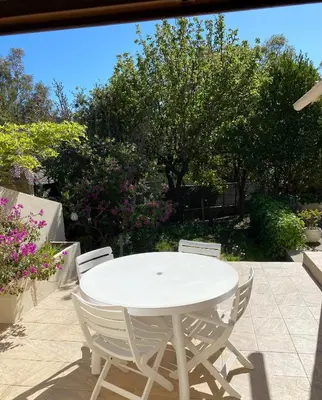 a white table and chairs on a patio at Maison à 150m de la plage naturiste, 2 chambres in Linguizzetta