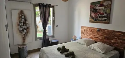 a bedroom with a bed and a brick wall at villas-majos : Magnifique villa vue mer à 3 minutes des plages in Sainte-Lucie de Porto-Vecchio