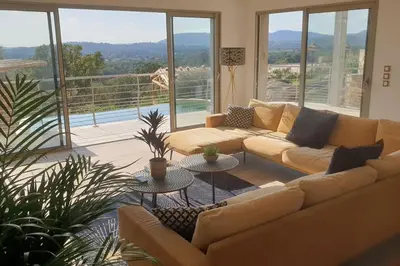 a living room with a couch and two tables at villas-majos : Magnifique villa vue mer à 3 minutes des plages in Sainte-Lucie de Porto-Vecchio
