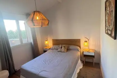 a bedroom with a bed and two lamps and a window at Villa A Liccia piscine 4pers proche Ville et Port in Porto-Vecchio