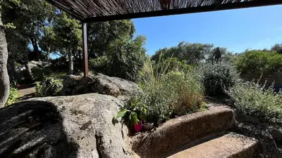 a garden with rocks and plants and a roof at Villa A Liccia piscine 4pers proche Ville et Port in Porto-Vecchio