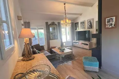 a living room with a table and a tv at Villa A Liccia piscine 4pers proche Ville et Port in Porto-Vecchio