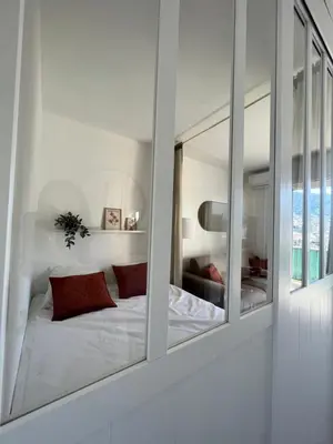 a bedroom with a mirror with a bed in it at Appartement ensoleillé à Ajaccio in Ajaccio