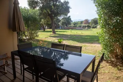 a table and chairs with a view of a park at Tamaricciu di cala rossa in Lecci