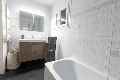 a white bathroom with a tub and a sink at Cocooning au cœur de la cité Impériale in Ajaccio