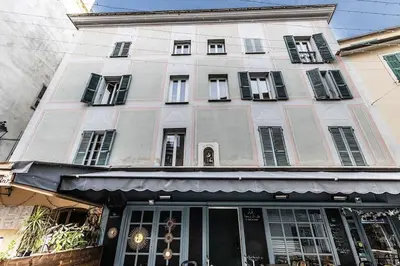 a large white building with black shuttered windows at Cocooning au cœur de la cité Impériale in Ajaccio