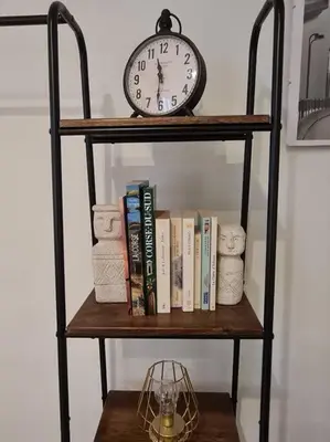 a clock sitting on top of a shelf with books at Cocooning au cœur de la cité Impériale in Ajaccio