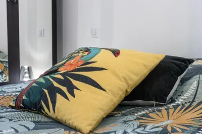 a pillow on top of a bed with a blanket at Cocooning au cœur de la cité Impériale in Ajaccio