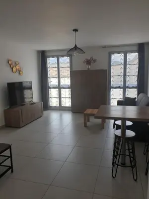 a living room with a table and a television at Appartement à deux pas du port de Bonifacio in Bonifacio