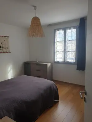 a bedroom with a bed and a dresser and a window at Appartement à deux pas du port de Bonifacio in Bonifacio