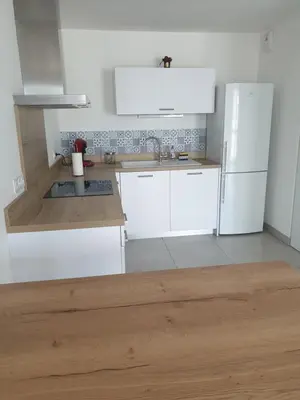 a kitchen with white cabinets and a white refrigerator at Appartement à deux pas du port de Bonifacio in Bonifacio