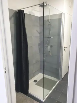 a shower with a glass door in a bathroom at Appartement à deux pas du port de Bonifacio in Bonifacio
