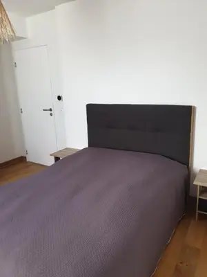 a bedroom with a large bed with a black headboard at Appartement à deux pas du port de Bonifacio in Bonifacio