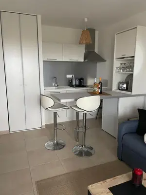 a kitchen with two stools and a counter in a room at Studio design front de mer classé 3 étoiles in Linguizzetta