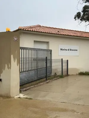 a house with a gate with a sign on it at Studio design front de mer classé 3 étoiles in Linguizzetta
