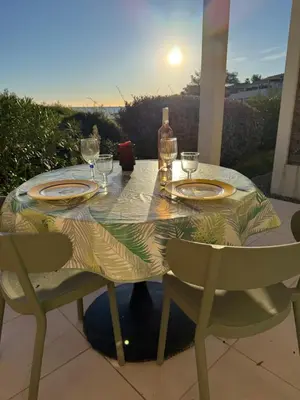 a table with plates and wine glasses on a patio at Studio design front de mer classé 3 étoiles in Linguizzetta