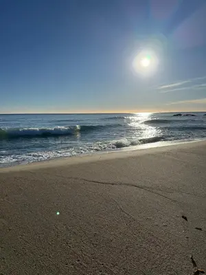 a beach with the sun rising over the ocean at Studio design front de mer classé 3 étoiles in Linguizzetta
