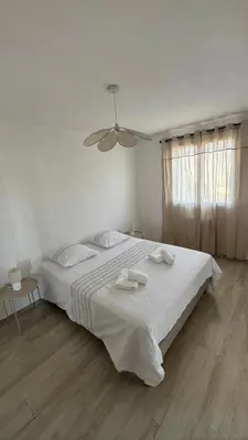 a white bedroom with a large bed with towels on it at Appartement T4 in Corte