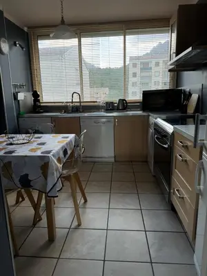 a kitchen with a table and a sink and a stove at Appartement T4 in Corte