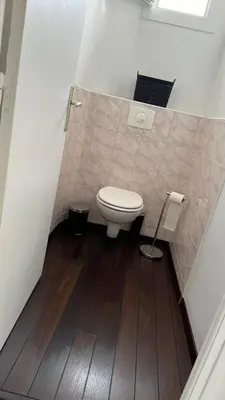 a bathroom with a toilet and a wooden floor at Appartement T4 in Corte