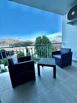 two chairs and a table on a balcony with a view at Appartement T4 in Corte