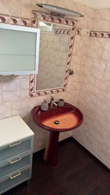 a bathroom with a red sink and a mirror at Appartement T4 in Corte