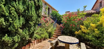 an alley with a stone table and stairs with flowers at Meublés de Tourisme Casa Erbaggio in Sartène