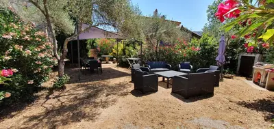 a patio with a table and chairs in a garden at Meublés de Tourisme Casa Erbaggio in Sartène