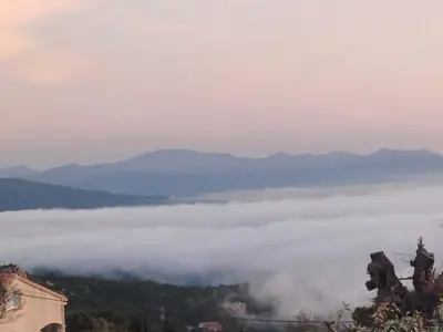 a view from the top of a mountain above the clouds at Cœur de village de charme in Sari Solenzara