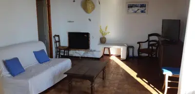 a living room with a white couch and a table at Cœur de village de charme in Sari Solenzara