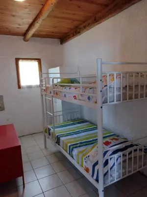two bunk beds in a room with a window at Cœur de village de charme in Sari Solenzara