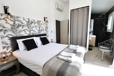 a bedroom with a large white bed and a chair at L'alivi, Villa Prestige Avec Vue Panoramique in Figari