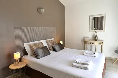 a bedroom with a bed with white sheets and pillows at L'alivi, Villa Prestige Avec Vue Panoramique in Figari