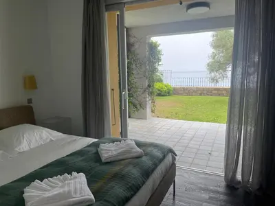a bedroom with a bed and a door to a patio at VILLA DOLCE VITA in Ajaccio
