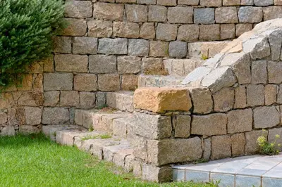 a stone retaining wall with a set of stone steps at VILLA DOLCE VITA in Ajaccio
