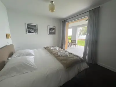 a bedroom with a bed and a large window at VILLA DOLCE VITA in Ajaccio