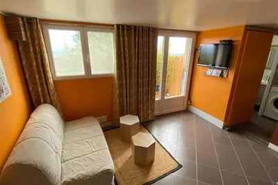 a living room with a couch and a tv at Tranquillité ,vue mer in Chiatra