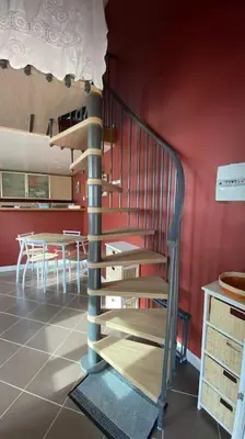 a spiral staircase in a room with a table at Tranquillité ,vue mer in Chiatra