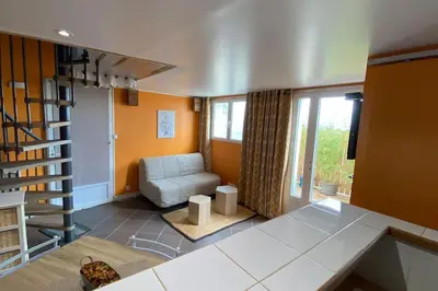 a living room with a couch and a stair case at Tranquillité ,vue mer in Chiatra