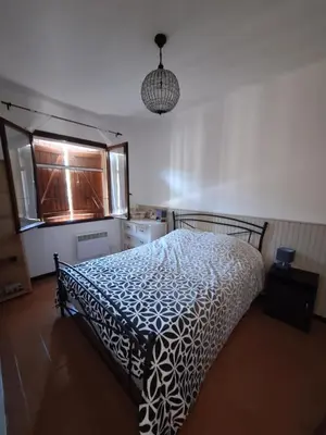 a bedroom with a bed with a black and white bedspread at F2 pieds dans l'eau in Casaglione