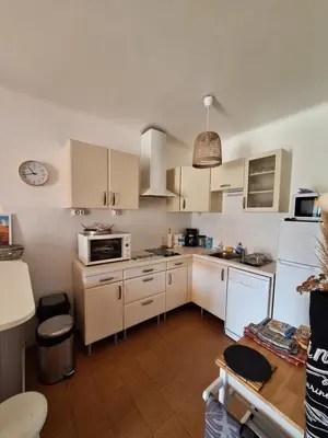 a kitchen with white cabinets and a white refrigerator at F2 pieds dans l'eau in Casaglione