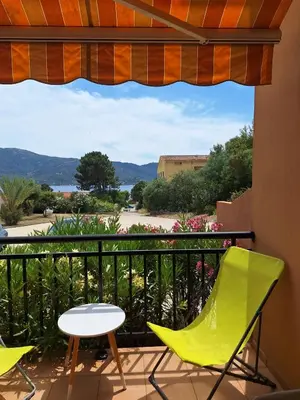 a balcony with chairs and a table and a view at F2 pieds dans l'eau in Casaglione